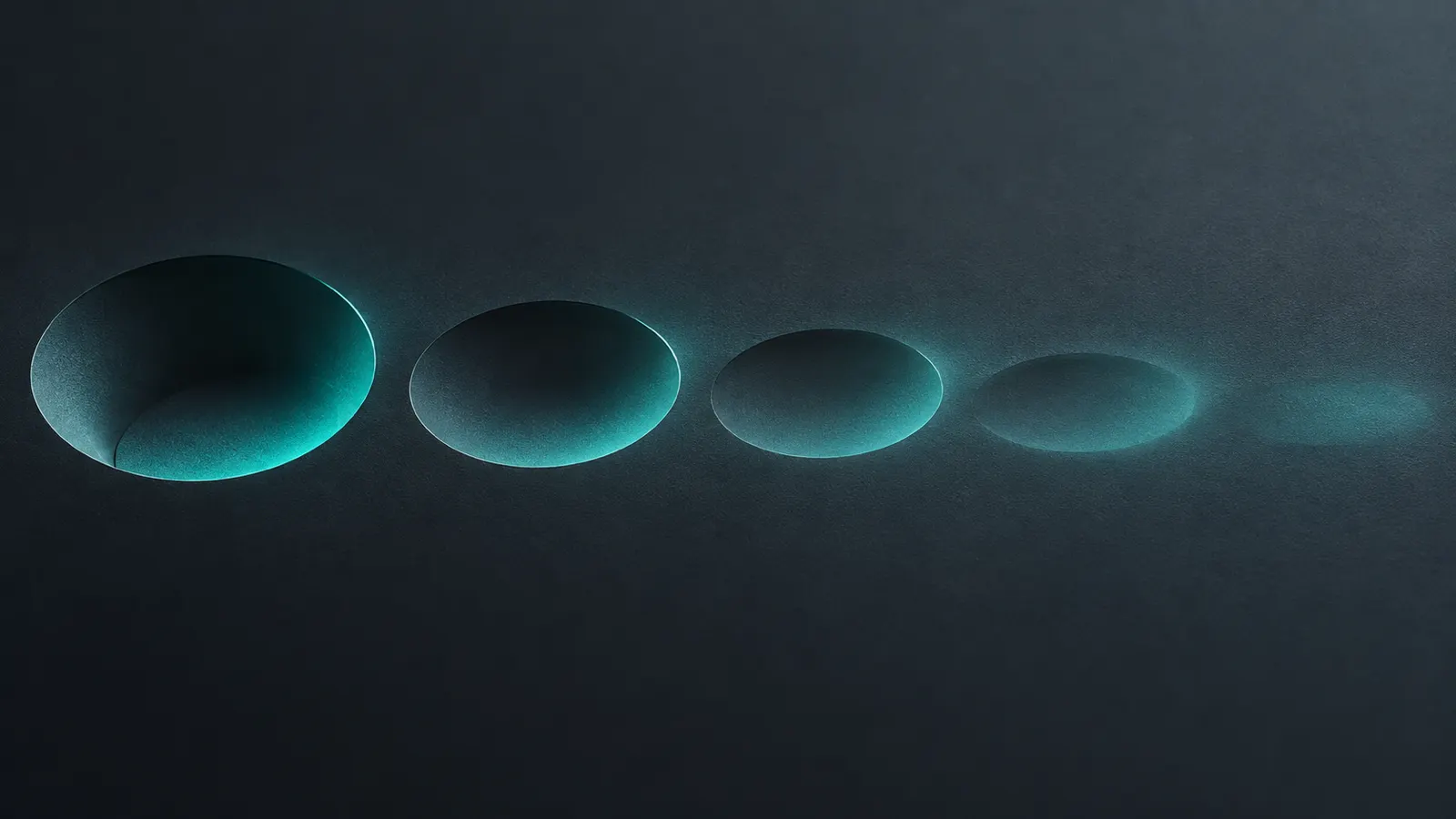 Graphite surface with shallow depressions that become smoother from left to right under teal light